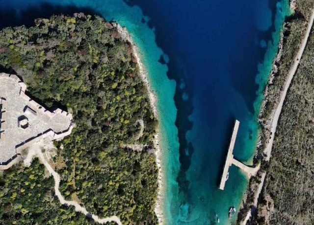 Playa de Porto Palermo en Albania con el agua azul turquesa y la arena de color tierra